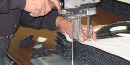 Cutting denim panels with a straight-knife machine